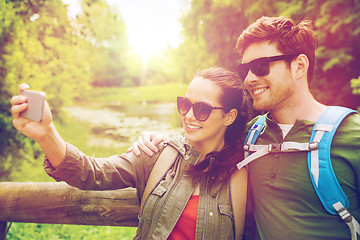 Image showing couple with backpacks taking selfie by smartphone