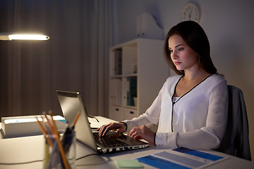 Image showing businesswoman with laptop at night office