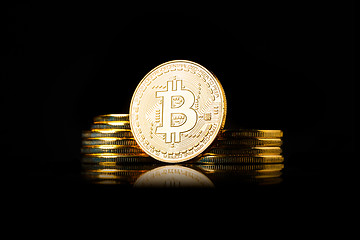 Image showing Stack of golden Bitcoin coins on a black background