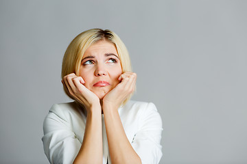 Image showing Model with hand at chin on empty gray background