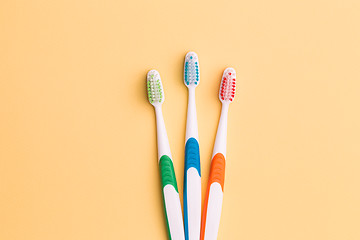 Image showing Toothbrushes on empty orange background