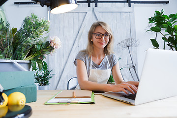 Image showing Blonde florist sitting at table