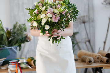 Image showing Florist in apron with bouquet