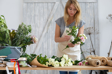 Image showing Young woman florist makes bouquet