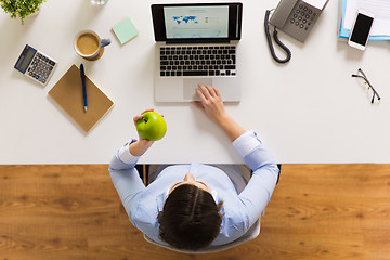 Image showing businesswoman with apple and laptop at office