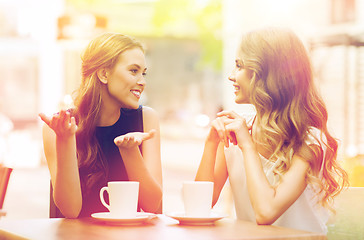 Image showing young women drinking coffee and talking at cafe