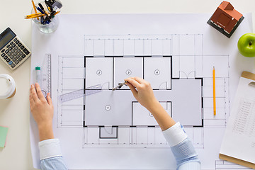 Image showing hands with compass measuring blueprint at office