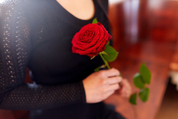 Image showing close up of woman with roses at funeral in church