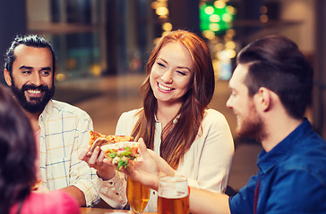 Image showing friends eating pizza with beer at restaurant