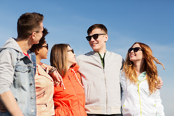 Image showing happy teenage friends in shades talking on street