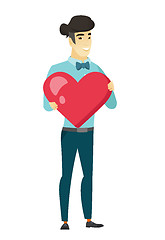 Image showing Asian business man holding a big red heart.