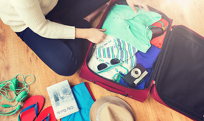 Image showing close up of woman packing travel bag for vacation