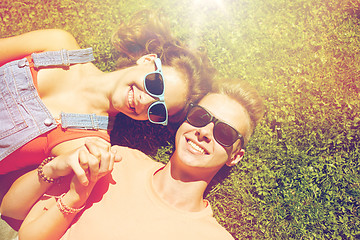 Image showing happy teenage couple lying on grass at summer