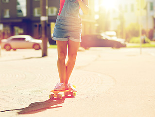 Image showing teenage girl riding skateboard on city street