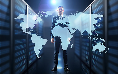 Image showing businessman with world map projection in corridor