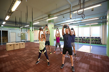 Image showing group of people with kettlebells exercising in gym