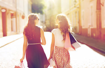 Image showing happy women with shopping bags walking in city 