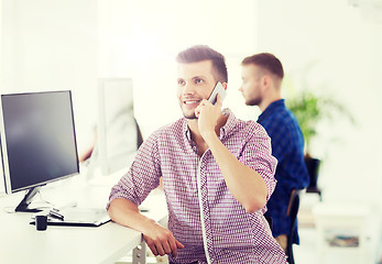 Image showing happy creative man calling on cellphone at office