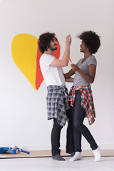 Image showing couple with painted heart on wall