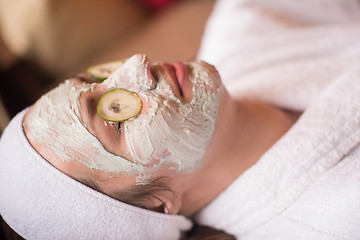 Image showing woman is getting facial clay mask at spa