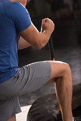 Image showing man workout with hammer and tractor tire