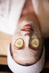 Image showing woman is getting facial clay mask at spa