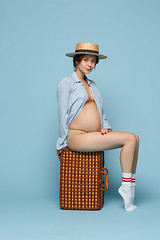 Image showing Young beautiful pregnant woman sitting on blue background