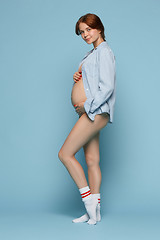 Image showing Young beautiful pregnant woman standing on blue background