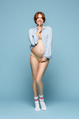 Image showing Young beautiful pregnant woman standing on blue background