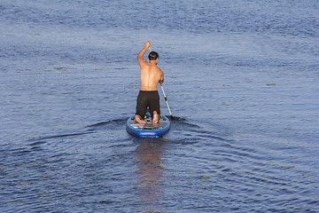 Image showing Man on Paddle Board paddling out to lake
