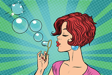 Image showing Young woman blowing bubbles