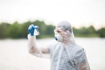 Image showing Ecologist holds flask with water