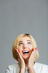 Image showing Surprised happy woman looking up