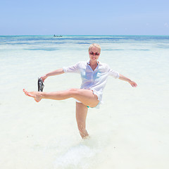 Image showing Young active woman having fun on vacations in shellow sea water.