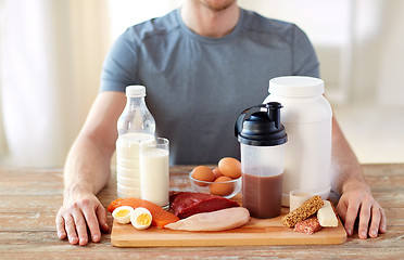 Image showing close up of man with food rich in protein on table