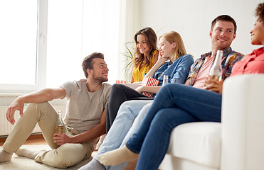 Image showing happy friends with popcorn and beer at home