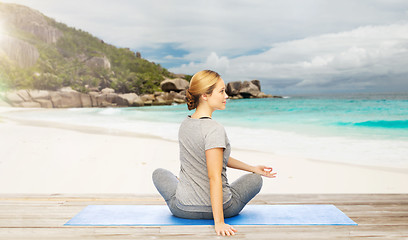 Image showing woman doing yoga in twist pose on beach