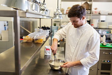 Image showing happy male chef cooking food at restaurant kitchen