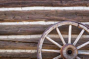 Image showing Abstract of Vintage Antique Log Cabin Wall and Wagon Wheel.