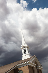 Image showing Church Steeple Tower Below Ominous Stormy Thunderstorm Clouds.