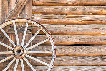 Image showing Abstract of Vintage Antique Log Cabin Wall and Wagon Wheel.