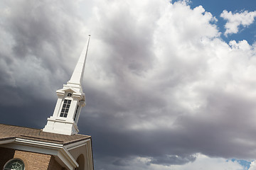 Image showing Church Steeple Tower Below Ominous Stormy Thunderstorm Clouds.