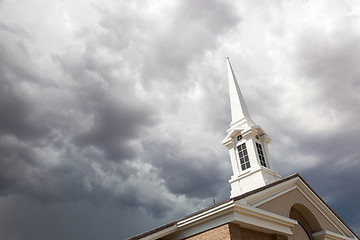 Image showing Church Steeple Tower Below Ominous Stormy Thunderstorm Clouds.