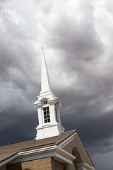 Image showing Church Steeple Tower Below Ominous Stormy Thunderstorm Clouds.