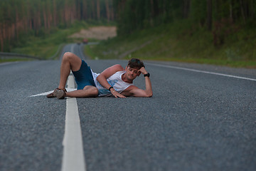 Image showing Man laying on the road