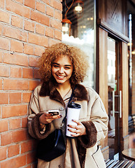 Image showing young pretty african american women drinking coffee outside in c