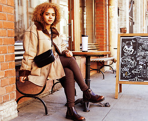 Image showing young pretty african american women drinking coffee outside in c