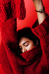 Image showing young pretty indian mulatto girl in red sweater posing emotional, fashion hipster teenage, lifestyle people concept