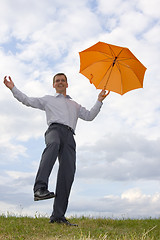 Image showing Happy businessman with orange umbrella