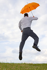 Image showing Happy businessman with orange umbrella